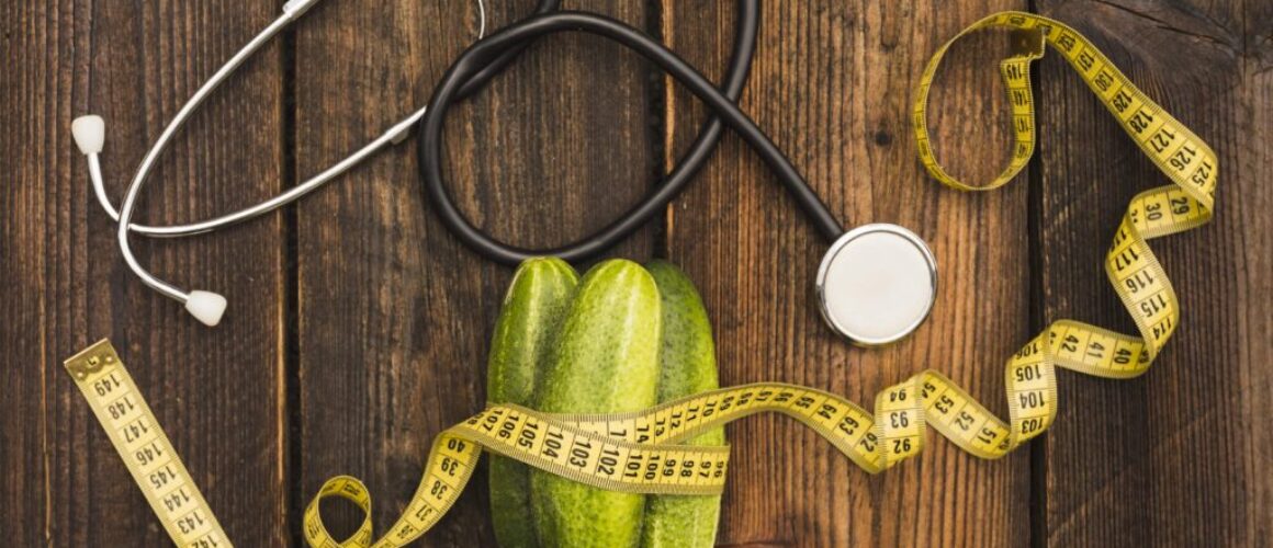 cucumbers-measuring-tape-stethoscope-wooden-surface